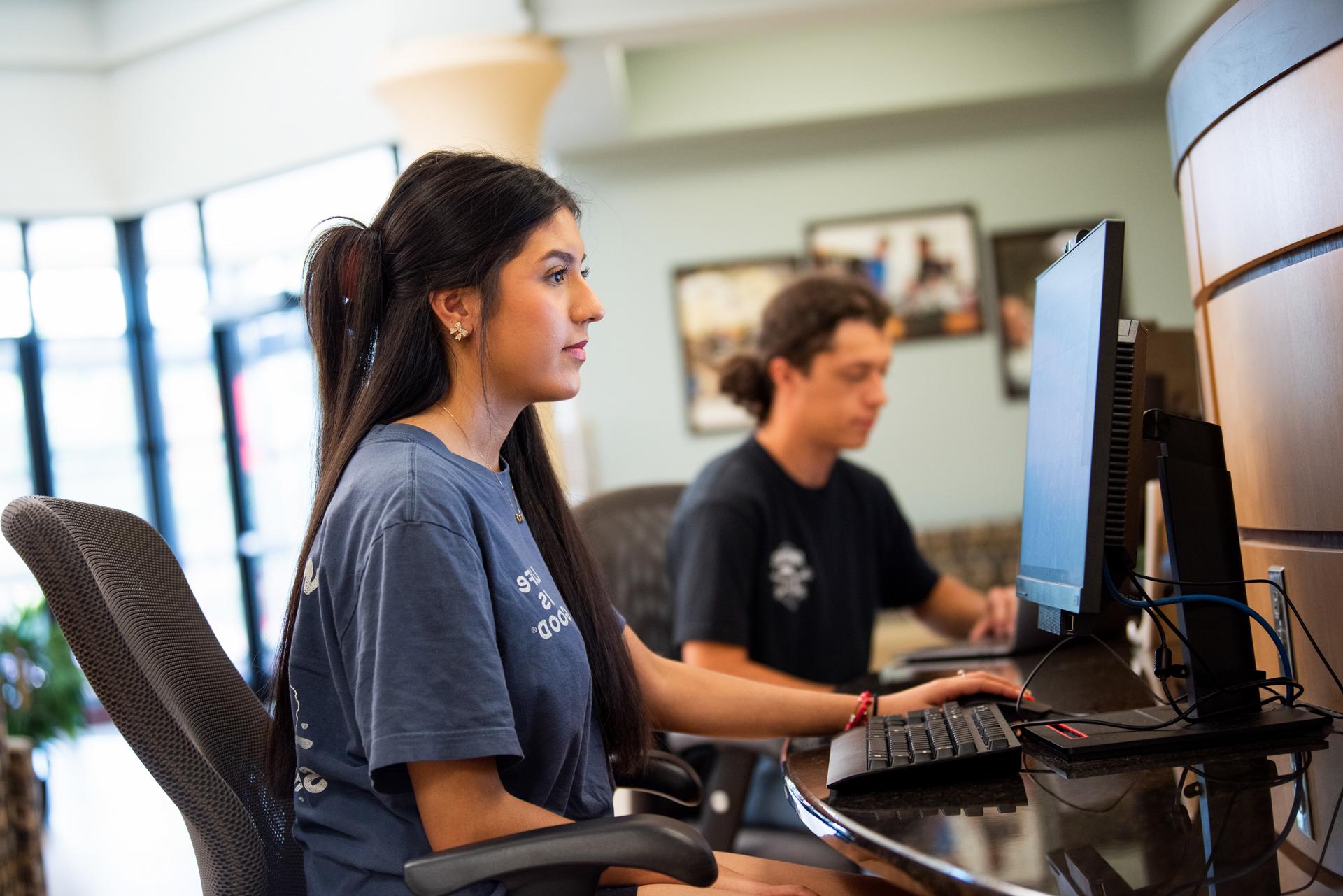 Returning student sits at computer in Navigation Station